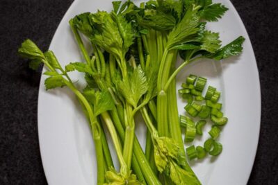 a white plate topped with green vegetables on top of a table
